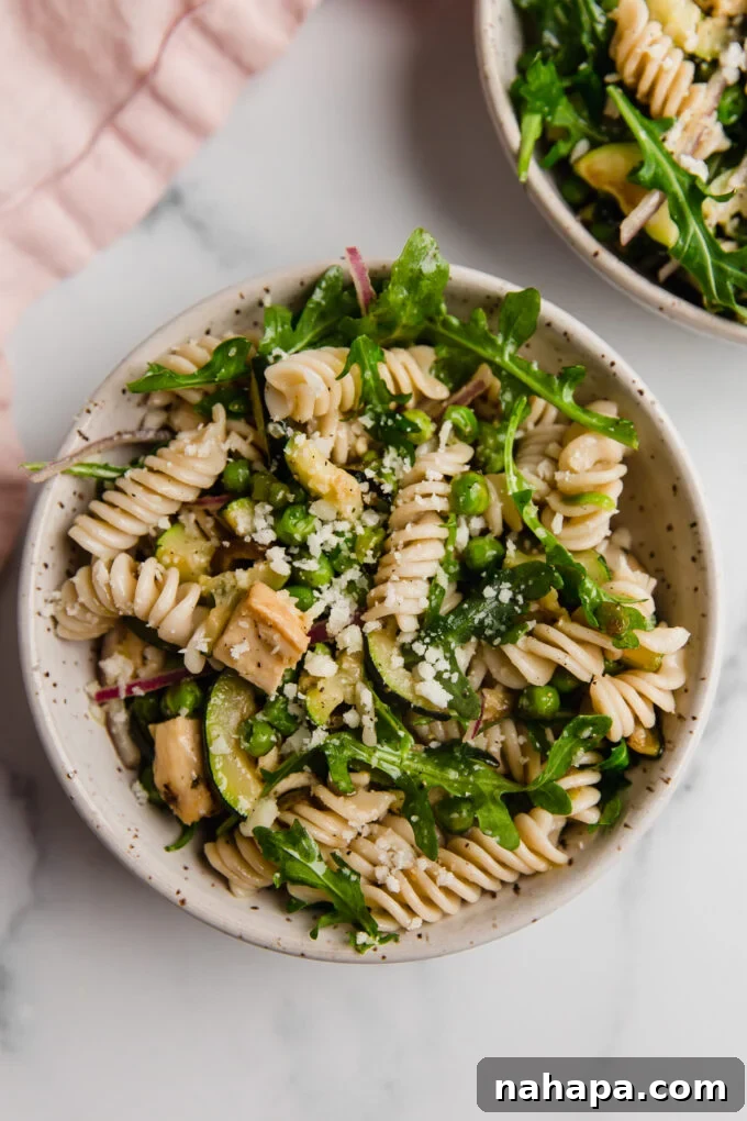 A close-up shot of the finished spring pasta salad, showcasing its vibrant colors and fresh ingredients, ready to be enjoyed.
