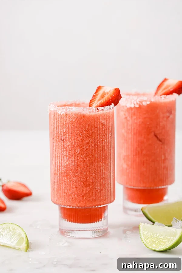 Close-up of a Strawberry Margarita Mocktail being poured into a salt-rimmed glass.