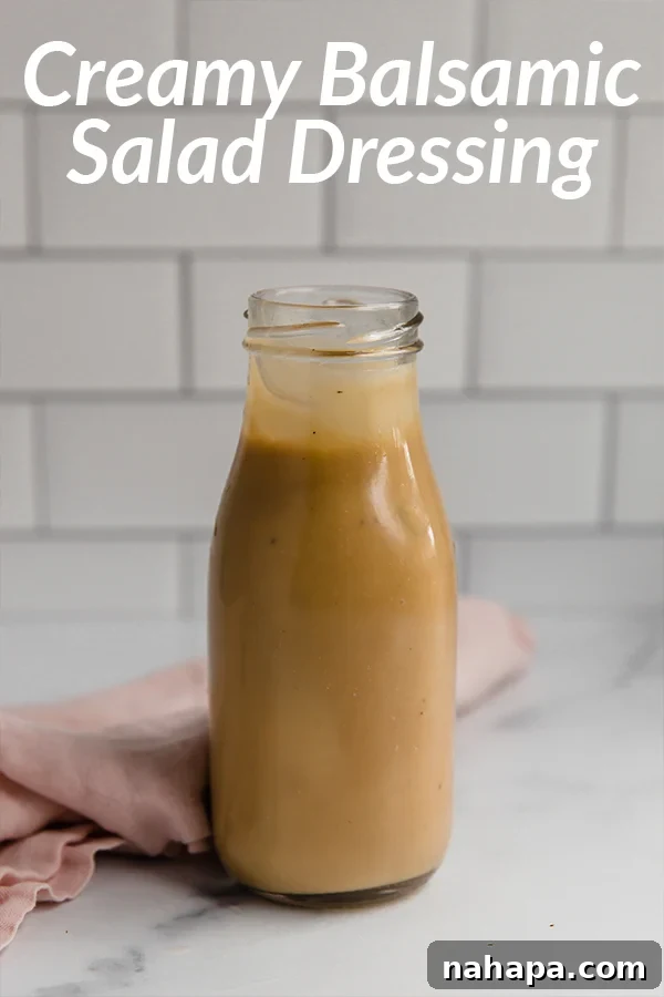 A small bowl of creamy balsamic dressing, rich and dark, garnished with a fresh herb sprig.