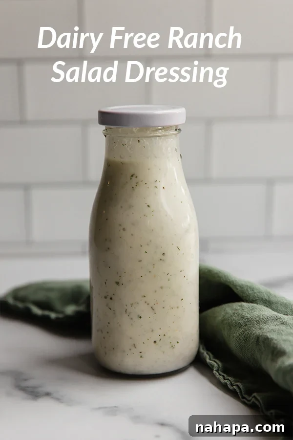 A bowl of creamy dairy-free ranch dressing, garnished with fresh herbs, alongside a plate of crisp vegetable sticks for dipping.