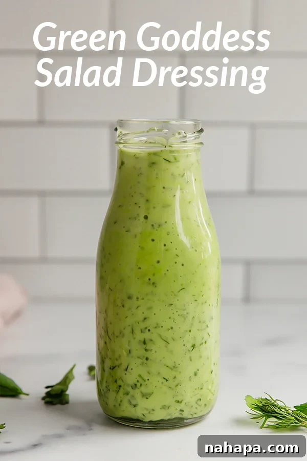 A creamy, pale green bowl of homemade green goddess dressing, garnished with fresh chives, ready for dipping or drizzling.