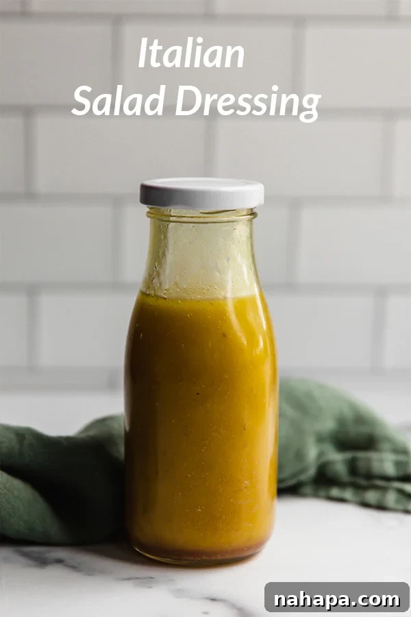 A clear glass bottle filled with vibrant Italian dressing, showcasing the herbs and spices suspended in oil and vinegar.