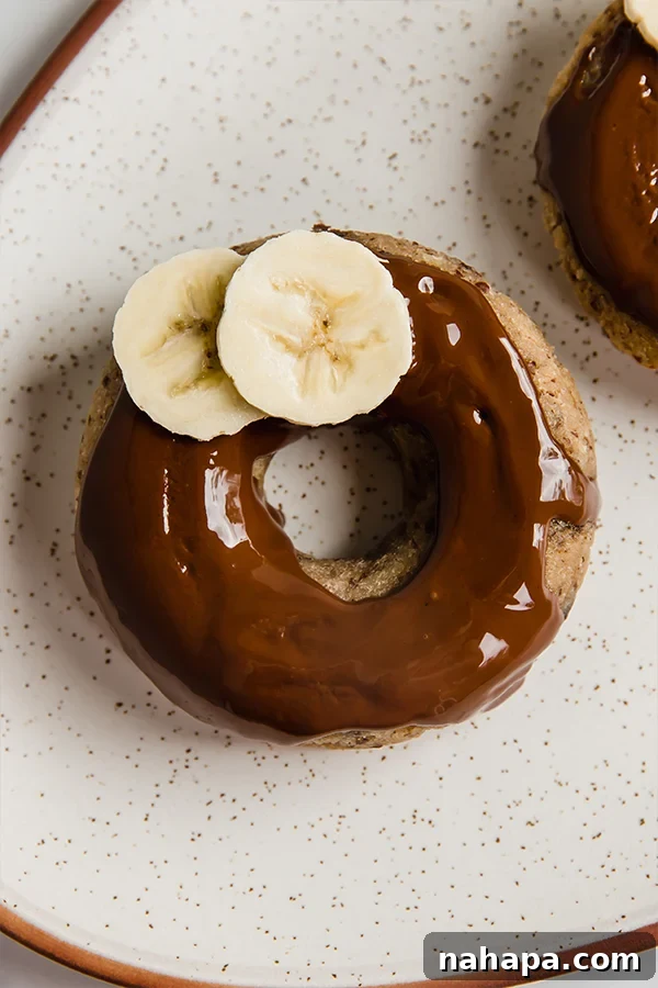 Perfectly glazed banana bread donuts arranged on a plate.