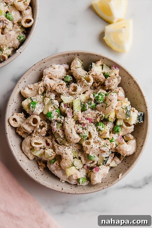 A close-up of healthy gluten-free tuna pasta salad, showcasing the texture of the grain-free pasta and the vibrant chopped vegetables, ready to be dressed.
