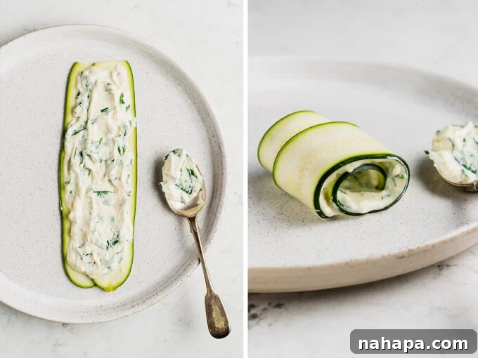 Slices of zucchini with creamy cauliflower ricotta and spinach spread on, ready to be rolled up