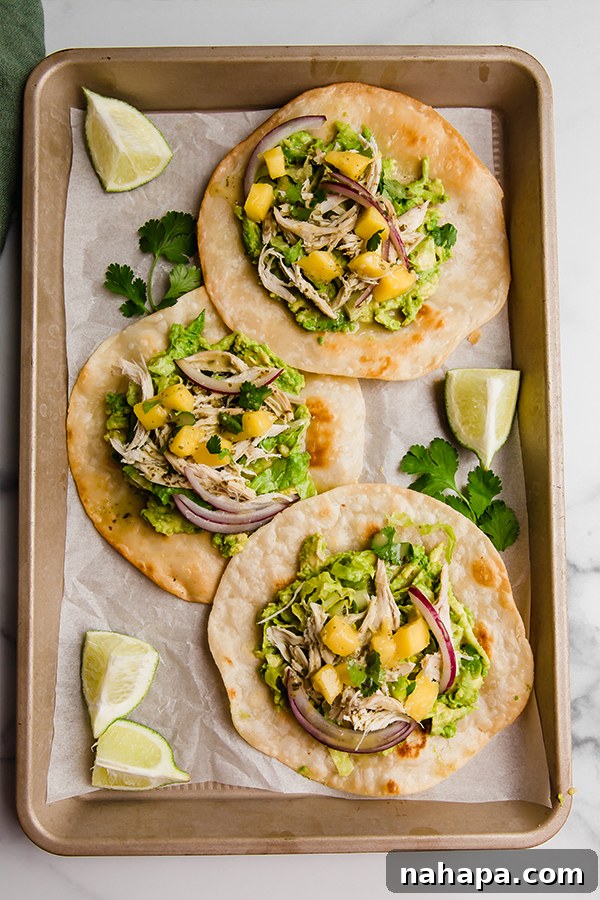 Tropical Paleo AIP Mango Chicken Tostadas 6 Three perfectly assembled Mango Chicken Tostadas, viewed from above on a baking sheet