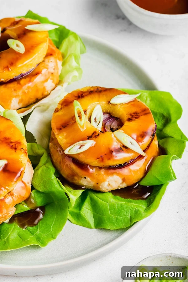 Overhead view of a prepared sweet and sour chicken burger, showing the vibrant colors of the toppings and sauce