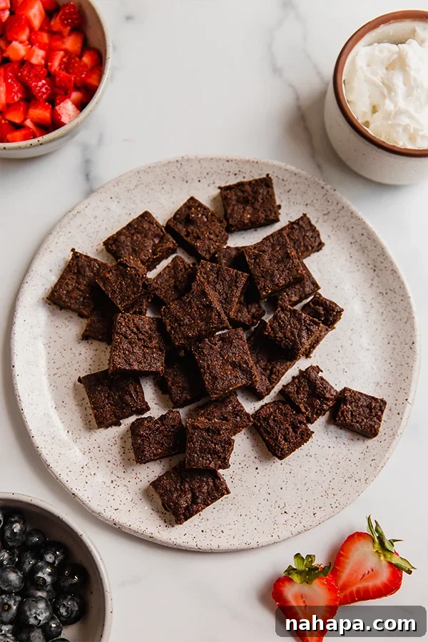 Brownie chunks on plate with other toppings in bowls