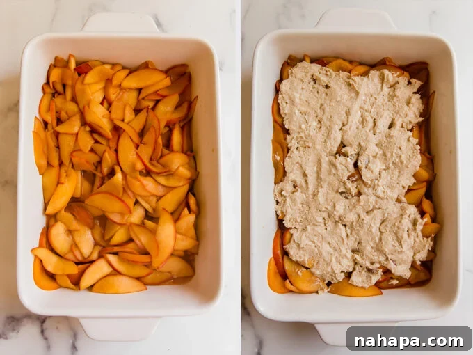 An overhead shot of a baking dish filled with a layer of glistening sliced peach mixture, topped with irregular, uncooked biscuit dough pieces, ready for baking.