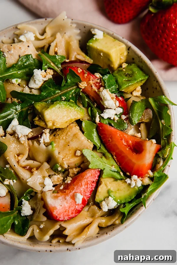 A vibrant close-up of the strawberry balsamic pasta salad, highlighting the texture and freshness of the ingredients.