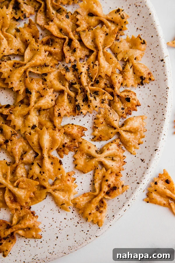 A vibrant bowl of crispy pasta chips, perfectly seasoned and ready to eat.