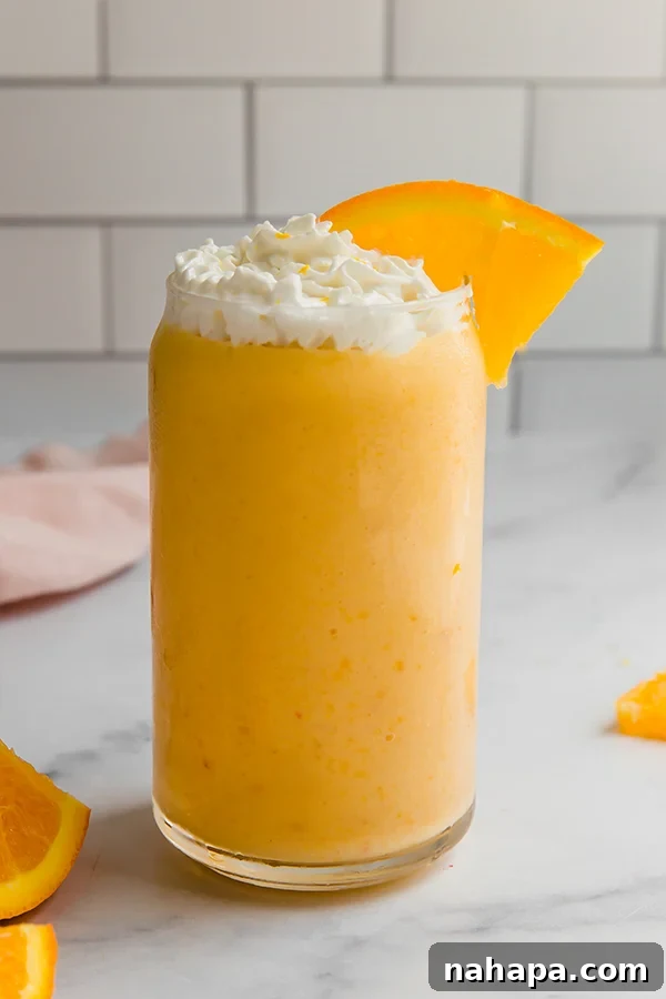 Healthy Banana-Free Orange Creamsicle Smoothie 4 Orange creamsicle smoothie in a glass with whipped cream and an orange slice on top