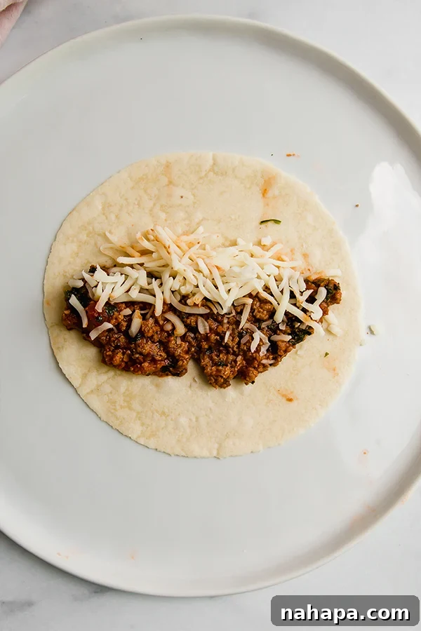 Wholesome Pizza Roll-Ups: Gluten-Free, Paleo, and AIP Friendly 3 A grain-free tortilla on a plate with meat and cheese filling