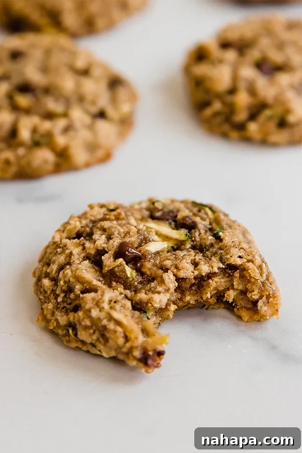 Oatmeal zucchini cookie with bite taken out of it on counter, showing its moist interior