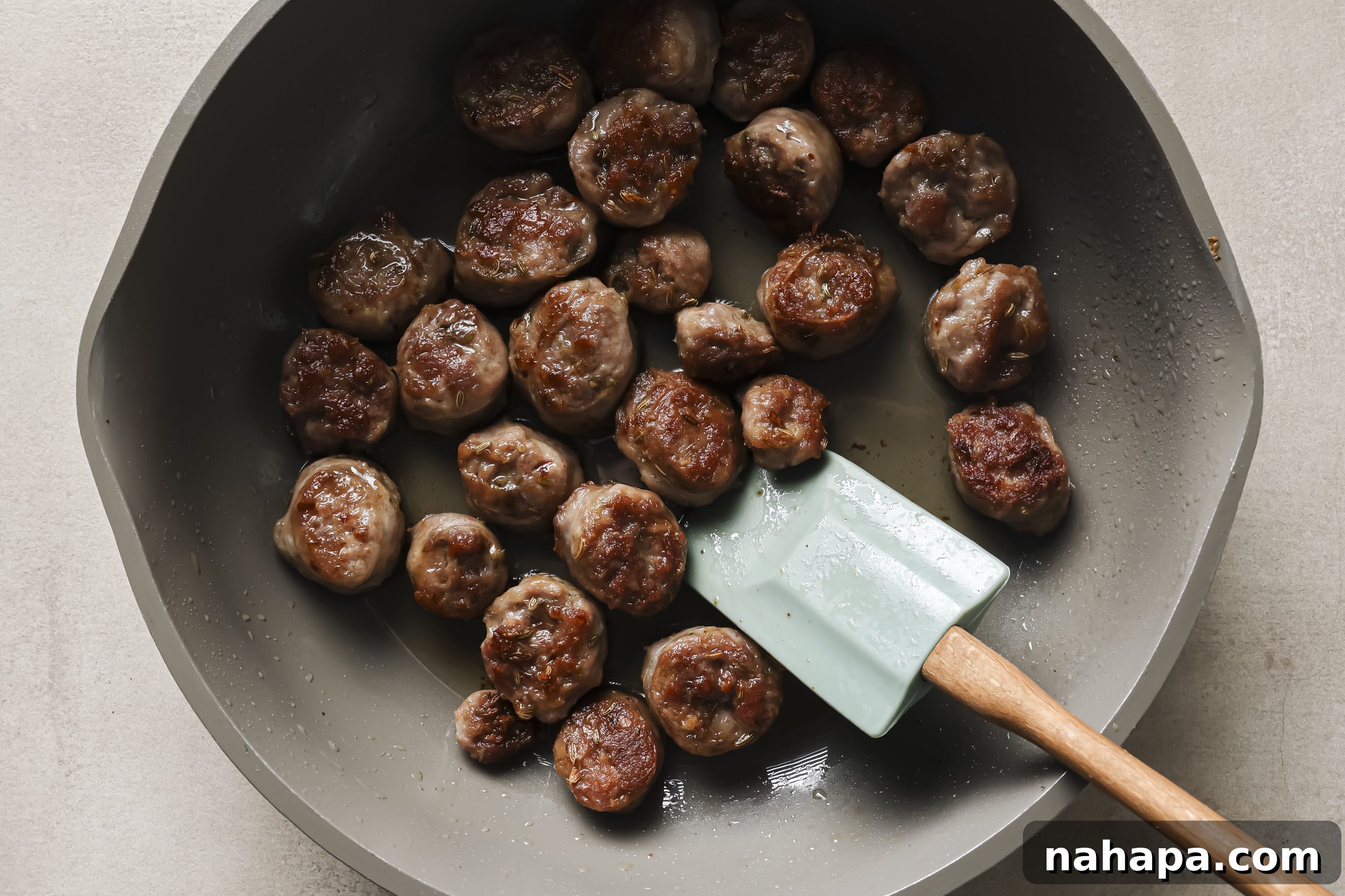 Savory sausage slices browning in a hot skillet, releasing their rich aromas.