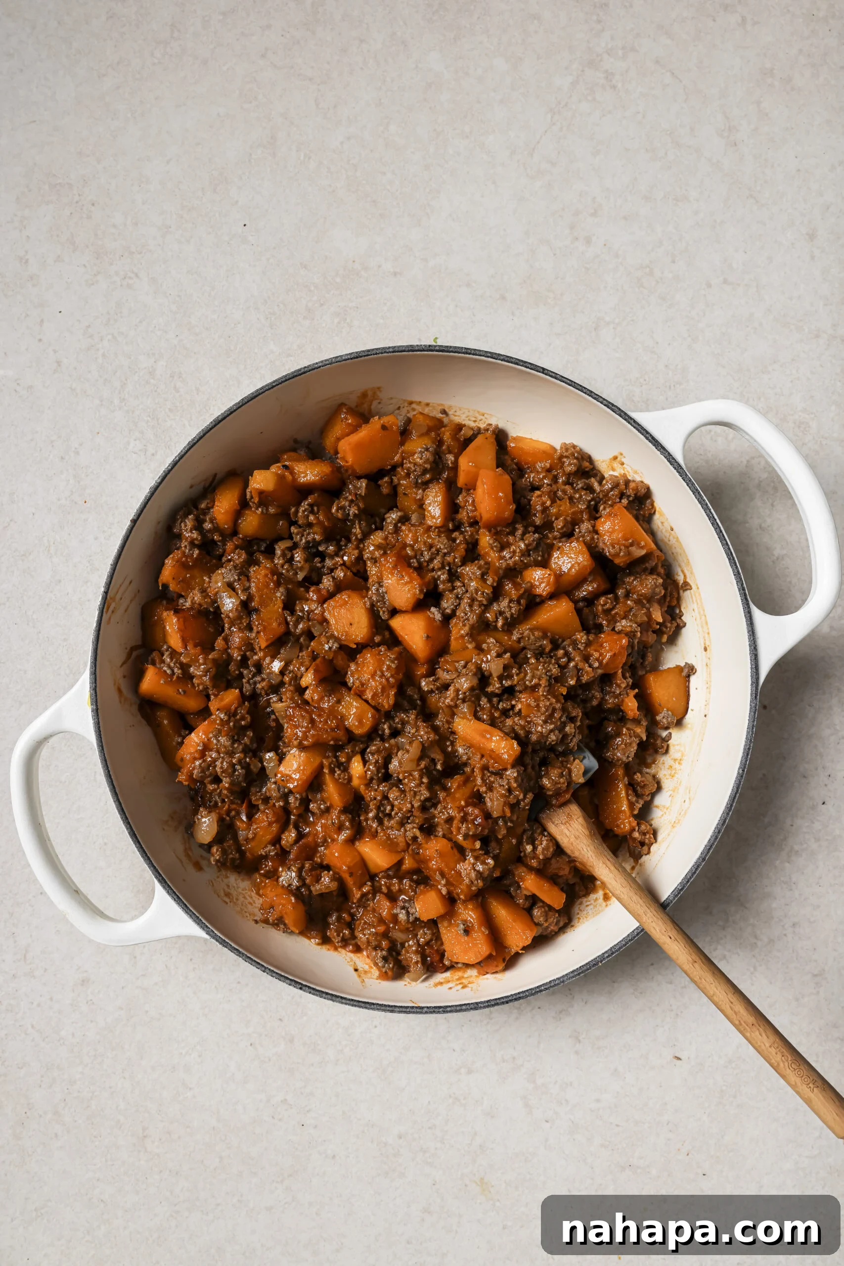 A large white pan with cooked ground beef and sweet potato.