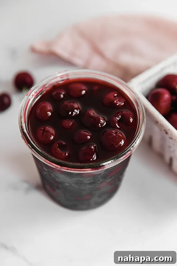 Homemade maraschino cherries in a glass jar, fresh and ready to serve.