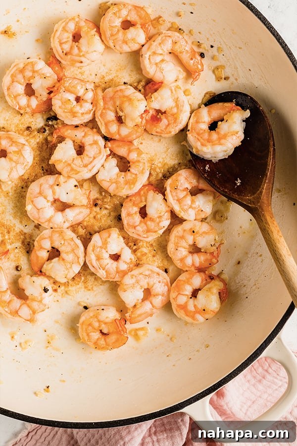Shrimp cooked in pan with wooden spoon