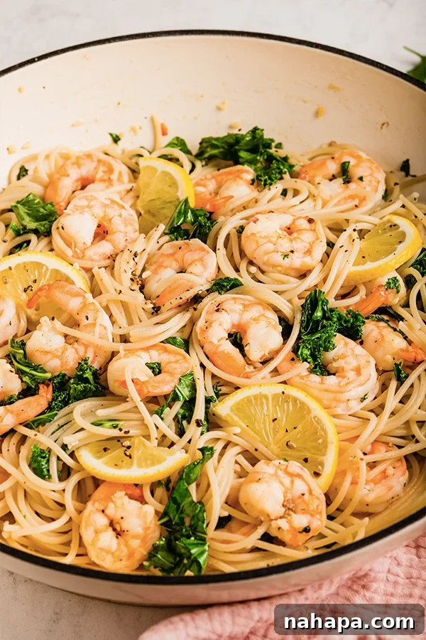 Lemon garlic shrimp pasta cooked in a pan with lemon slices