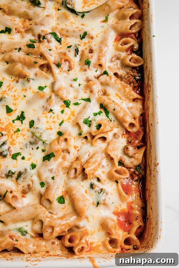 A close-up shot of a serving of gluten-free no-boil pasta bake with ground beef and spinach.