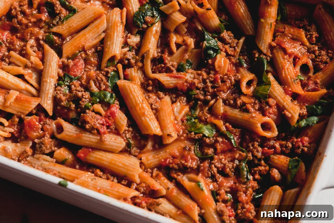 Fresh spinach leaves are stirred into the hot pasta bake to wilt.