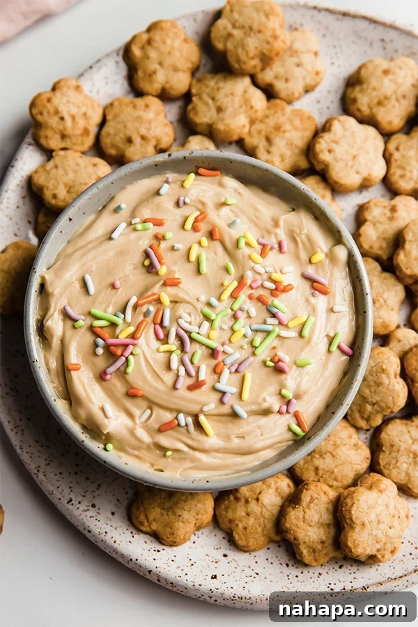 Copycat Dunkaroo cookies surrounding a bowl of icing with sprinkles.