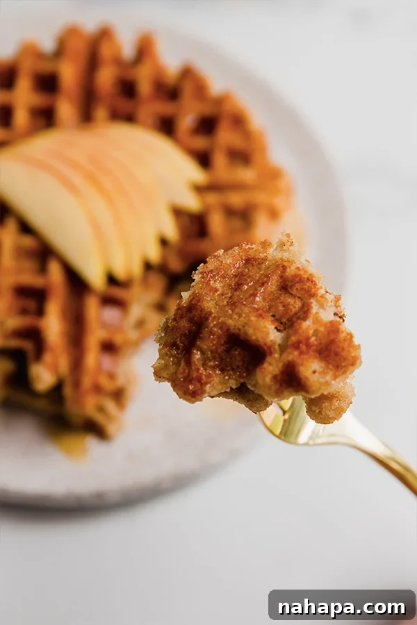 Wholesome Apple Waffles Gluten Free Paleo Vegan 3 A bite of gluten-free apple waffle on a fork, showing its fluffy texture.