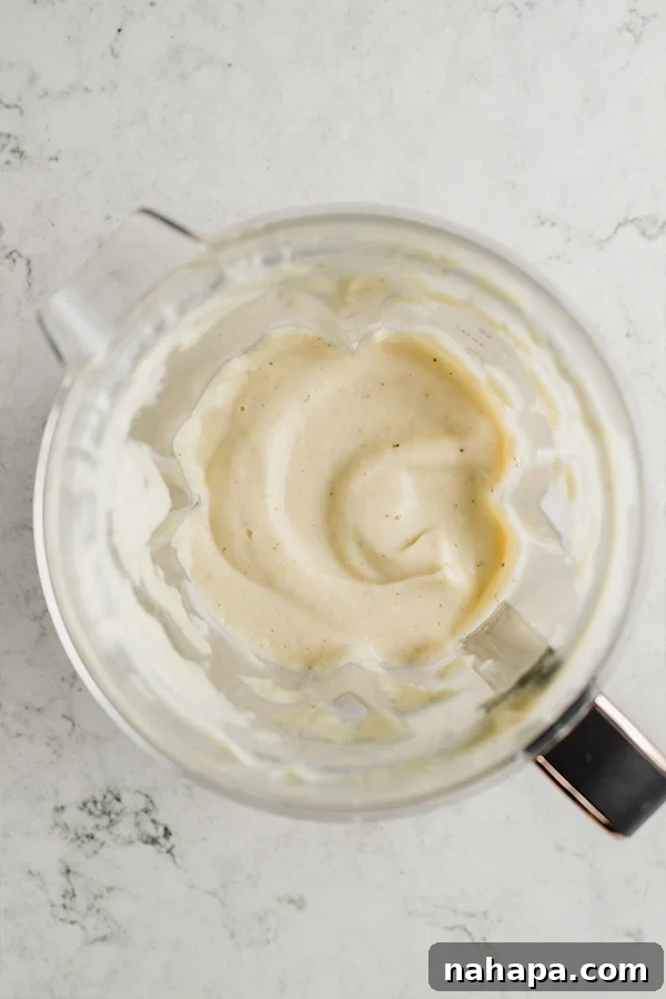 A blender filled with alfredo sauce.