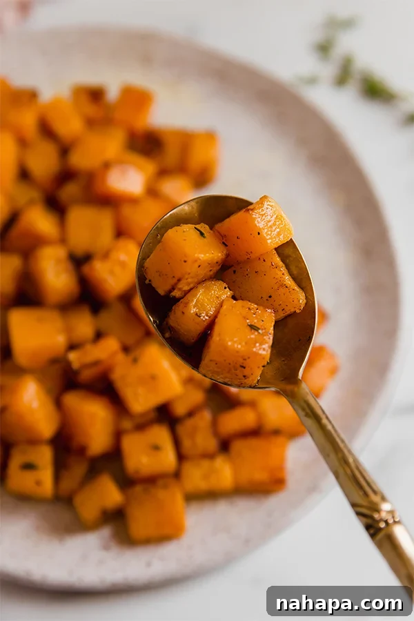 A single cubed piece of golden-brown air-fried butternut squash resting on a spoon.