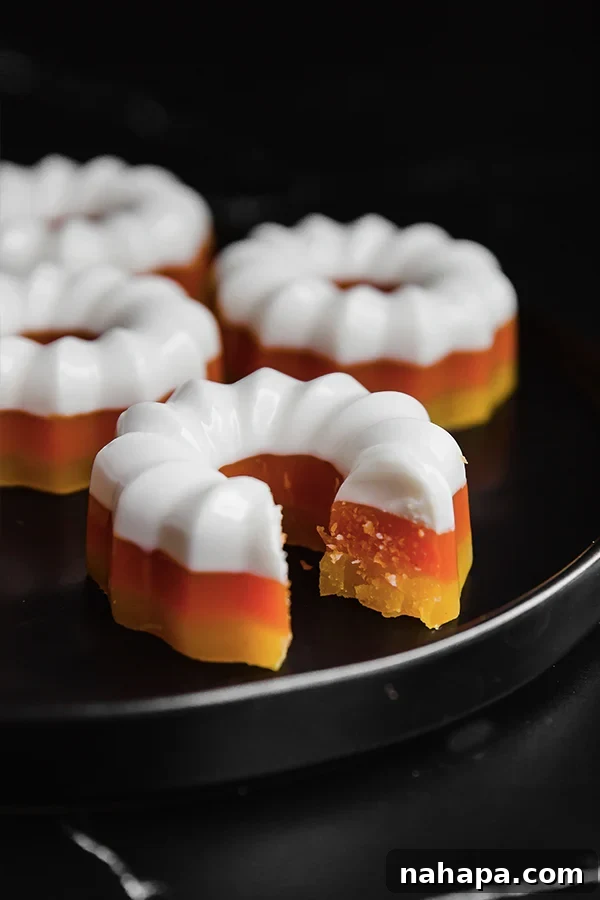 Closeup of perfectly layered homemade candy corn gelatin molds, showcasing white, orange, and yellow