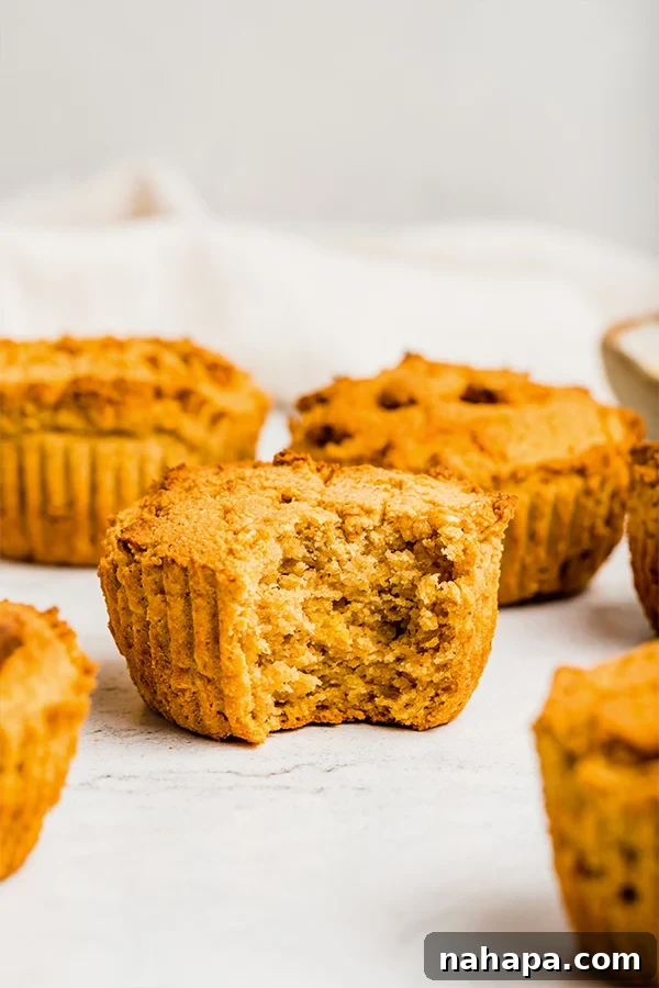 A perfectly baked grain-free cornbread muffin with a bite taken out, revealing its soft interior.