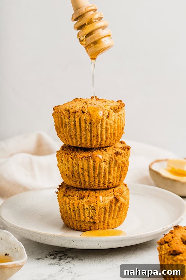 A beautiful stack of grain-free cornbread muffins, generously drizzled with golden honey.