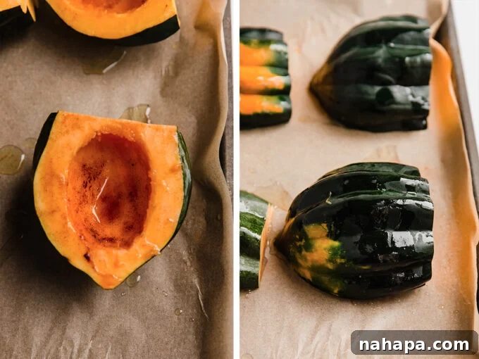 Two halves of acorn squash on a sheet pan, seasoned and ready for roasting.