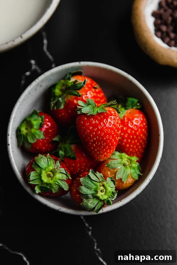 A bowl of fresh strawberries, ready for transformation into ghosts.