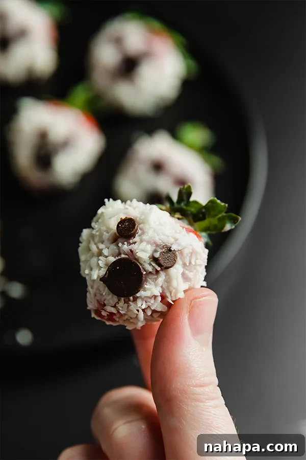 One strawberry ghost in a hand, showcasing its playful design.