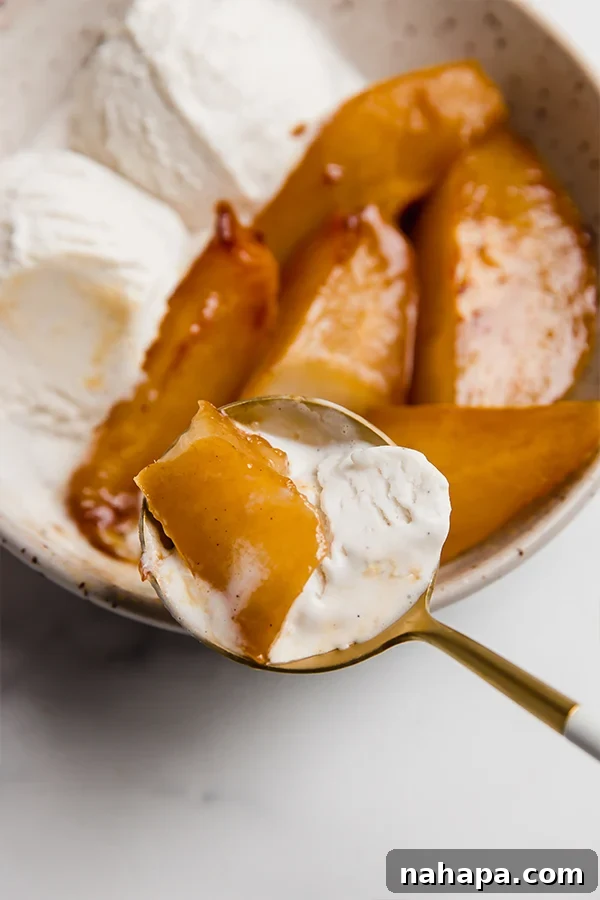 A close-up shot of a fork taking a bite of caramelized pear with a dollop of ice cream, highlighting the perfect texture.
