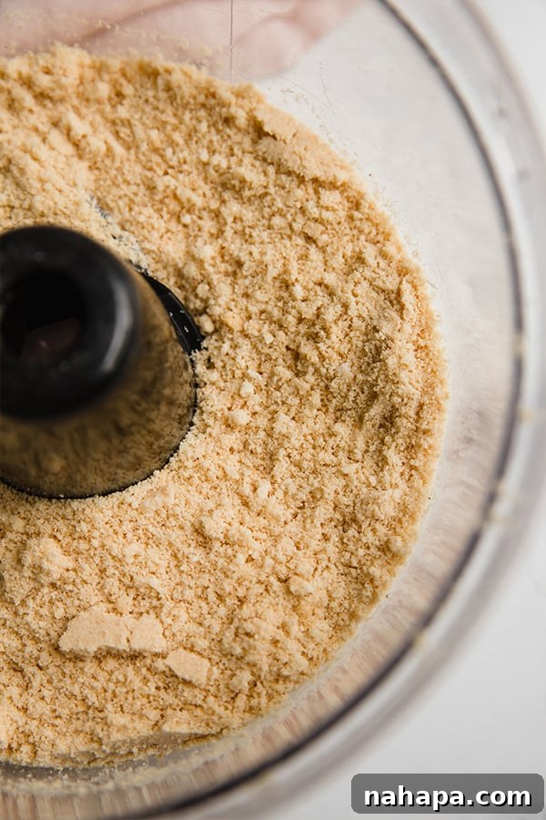 Food processor blending Lovebird cereal into fine crumbs for a grain-free pie crust.
