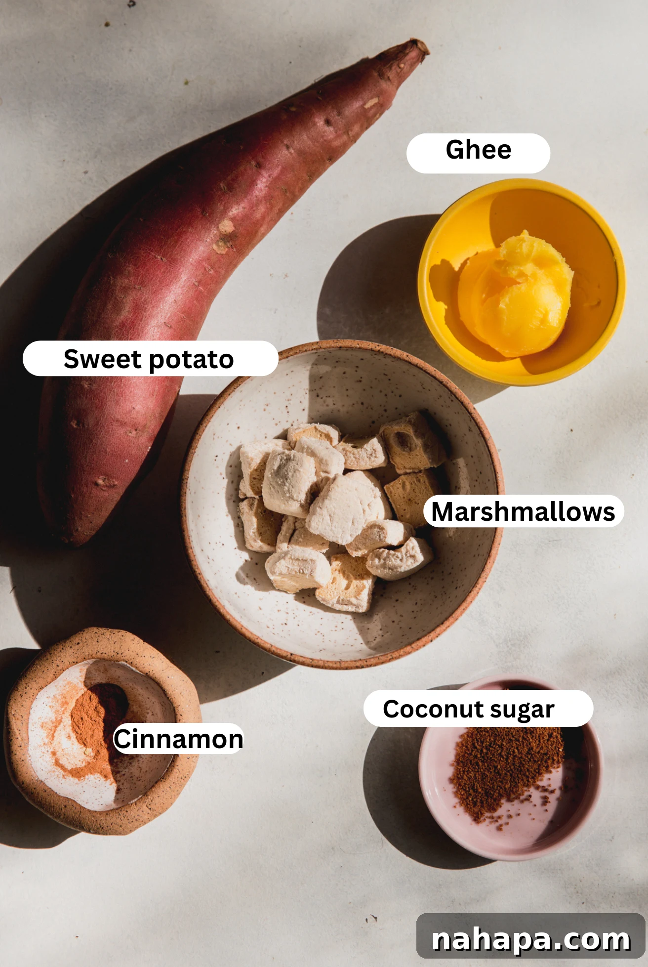 Ingredients laid out for sweet potato casserole bites, including sweet potatoes, ghee, coconut sugar, and marshmallows.
