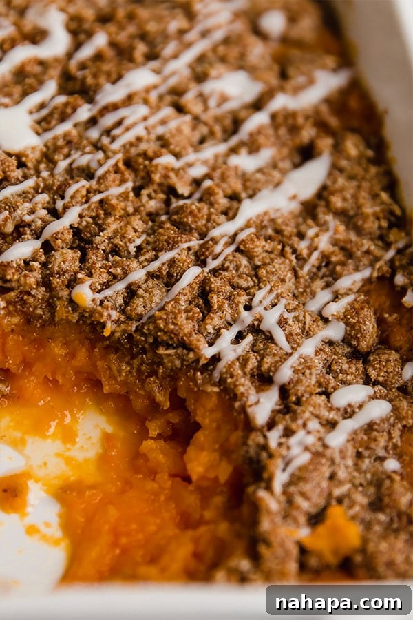 A pan of sweet potato casserole with a serving taken out.