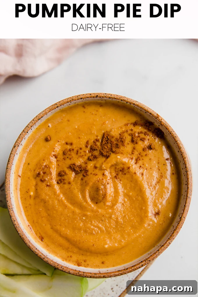 A graphic showcasing a bowl of pumpkin pie dip surrounded by fall foliage, with text promoting the recipe to be saved.