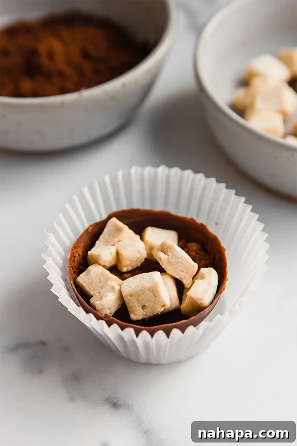 Cocoa shells filled with hot cocoa mix and marshmallows in cupcake liners