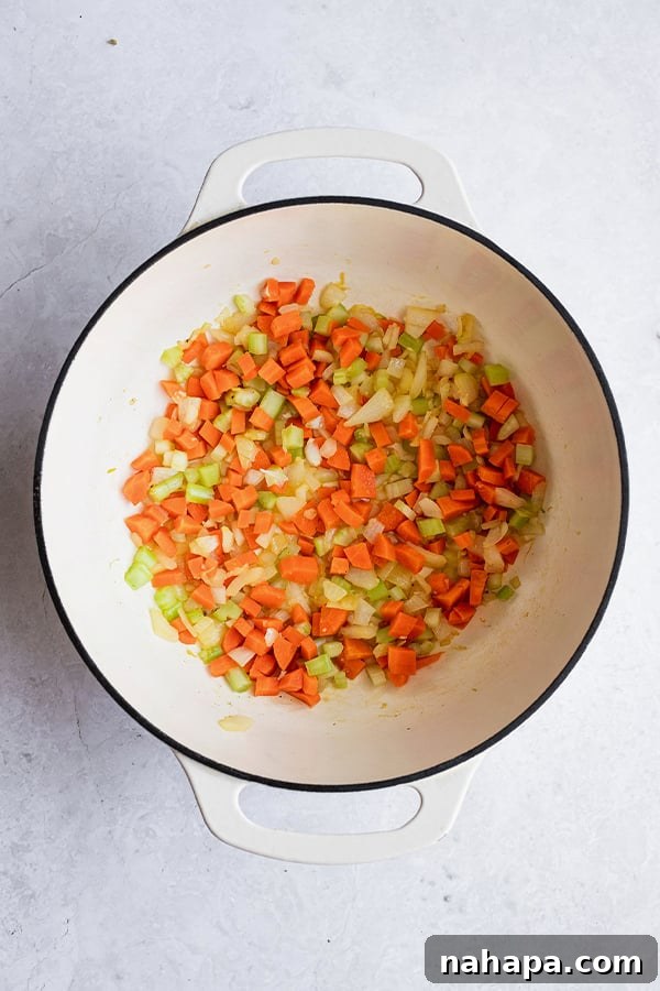 Freshly diced carrots, onions, and celery, ready to be sautéed to form the aromatic base of the soup.