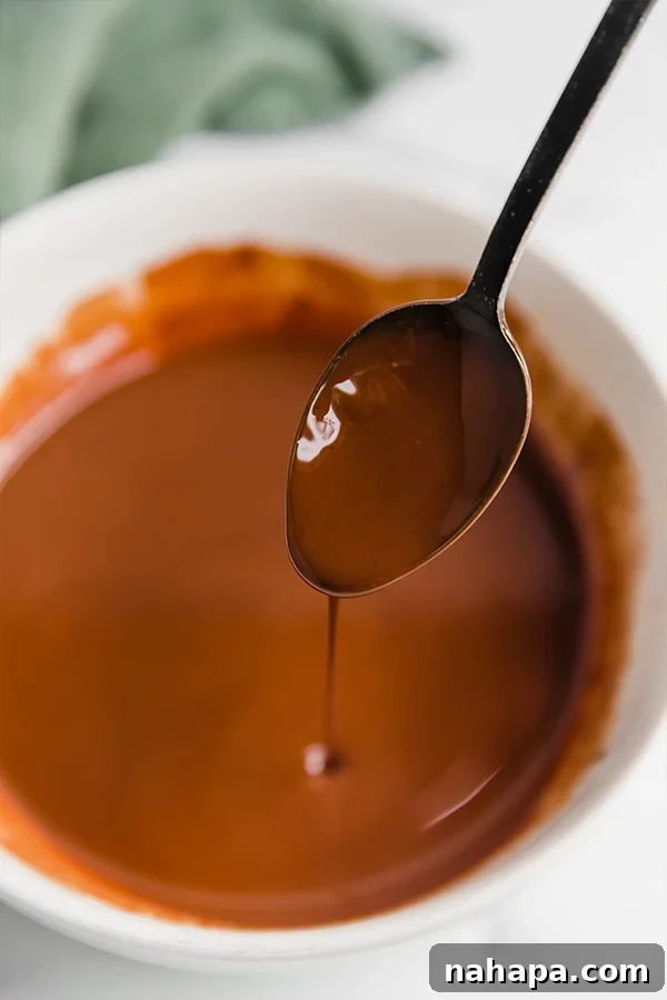 Melting chocolate, nut butter, and ghee in a bowl for puppy chow