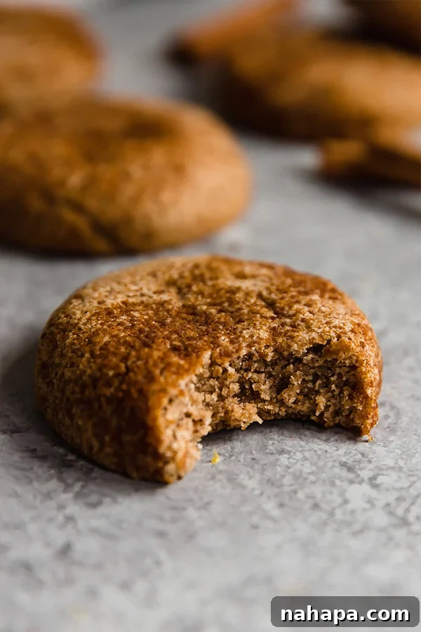 A chai snickerdoodle cookie with a bite taken out, showcasing its soft interior.