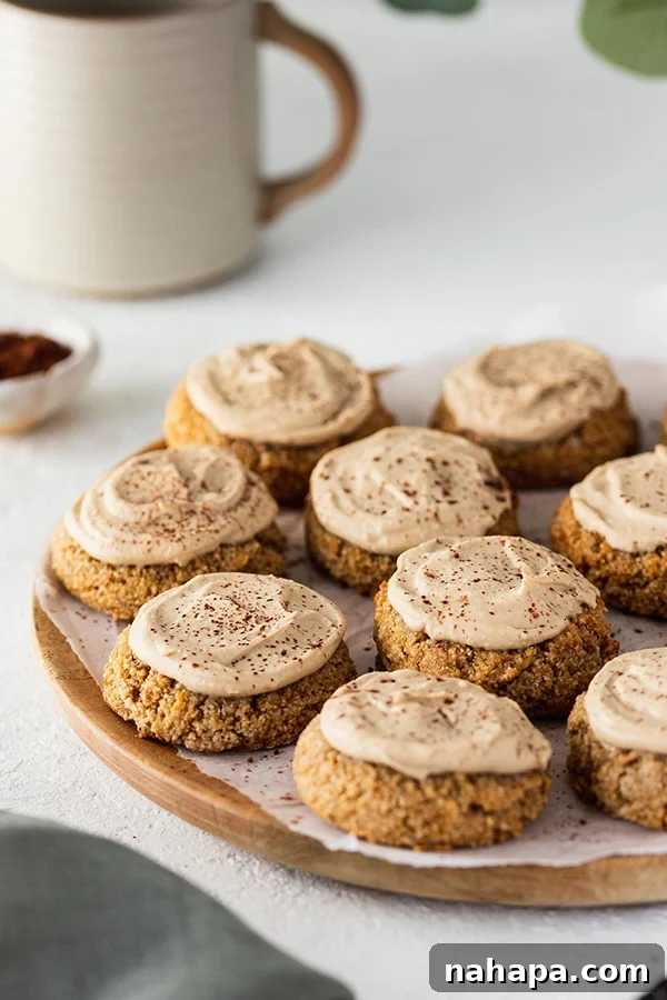 Individual Tiramisu cookies, topped with creamy frosting and dusted with cocoa powder, arranged beautifully on a plate.