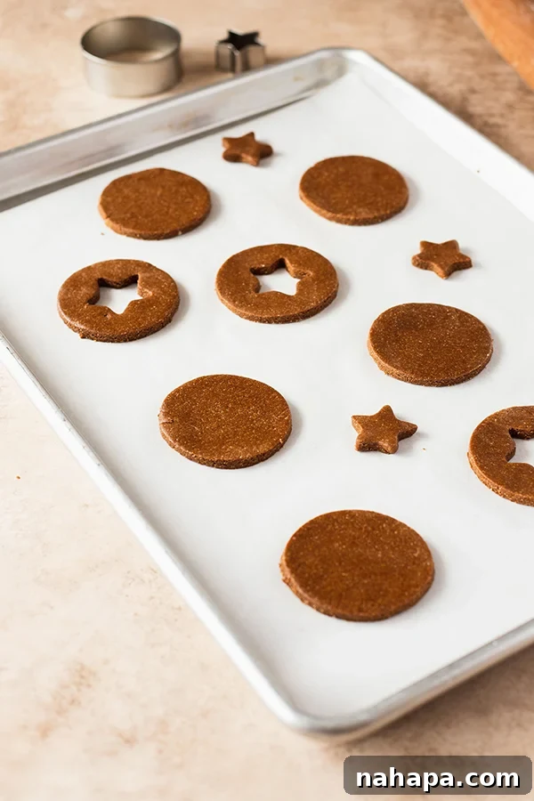 Chocolate Gingerbread Sandwich Cookies Paleo AIP 5 Gingerbread cookie dough circles with small peekaboo cutouts in the center, ready for baking.