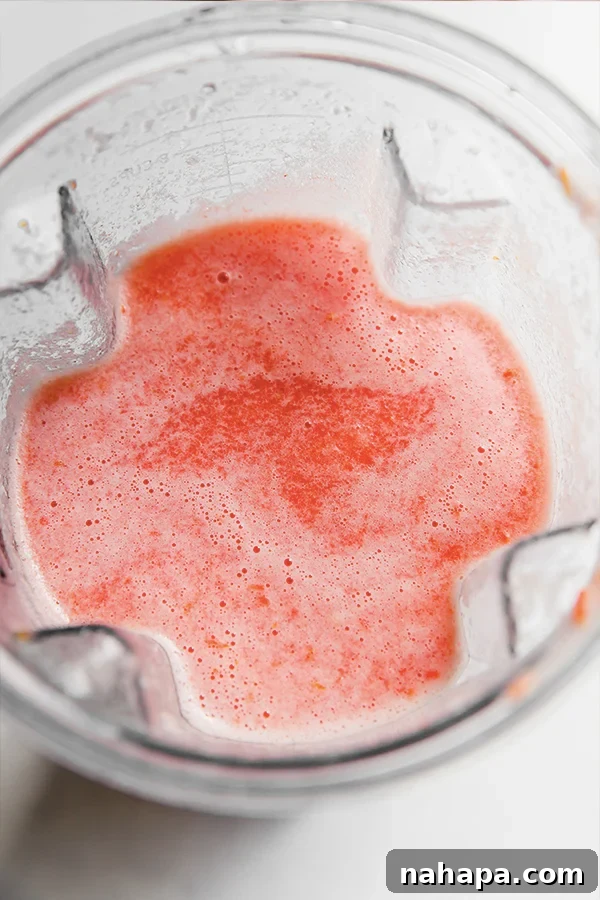 A blender full of broth ingredients before blending.