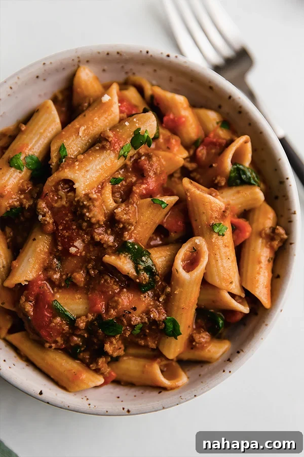 A bowl of instant pot pasta with a spoon, ready to be enjoyed.