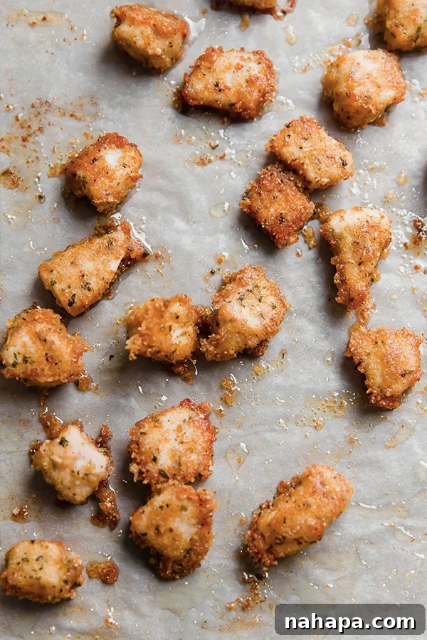 Golden brown pork panko chicken nuggets on a baking sheet after cooking, looking perfectly crispy.