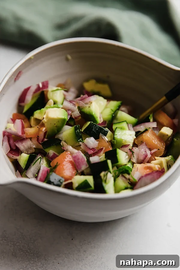 A bowl of freshly chopped vegetables for Greek Salsa Salmon bowls, perfectly mixed and ready.